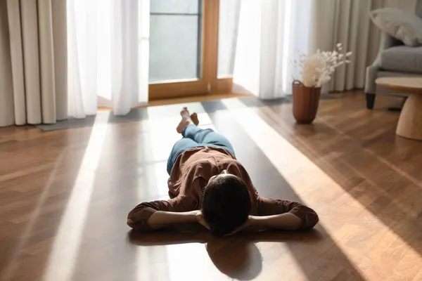 Happy young indian woman lying on warm floor. — Stok Foto