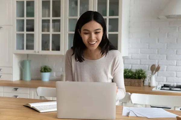 アジアの女性はノートパソコンを見て笑顔商品ニュースを読む — ストック写真