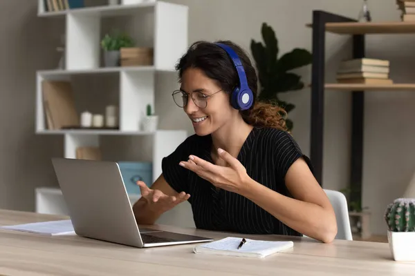 Spaanse vrouwelijke tolk in headset werken op afstand praten gebruik laptop — Stockfoto