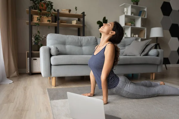 Ajuste joven hispana hacer yoga en el suelo antes de la computadora portátil — Foto de Stock