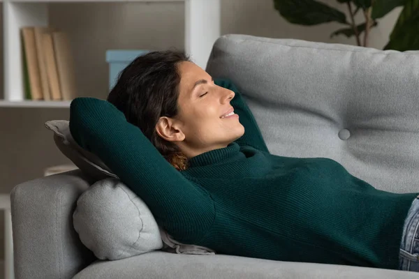 Spokojna, millenium latynoska kobieta leżąca na plecach śpiąca na kanapie — Zdjęcie stockowe