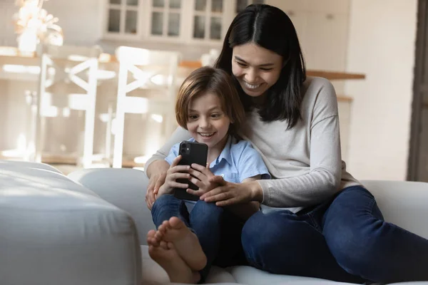 Mujer asiática su hijo mirando la pantalla del teléfono celular disfrutar de la aplicación — Foto de Stock