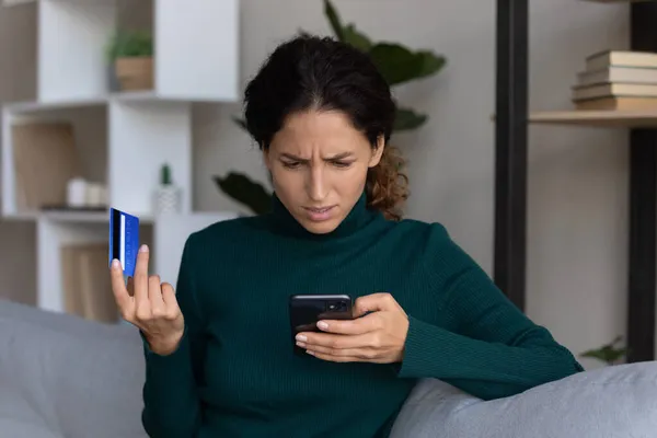 Занепокоєна леді, дивлячись на смартфон, що викрав фінанси з картки — стокове фото