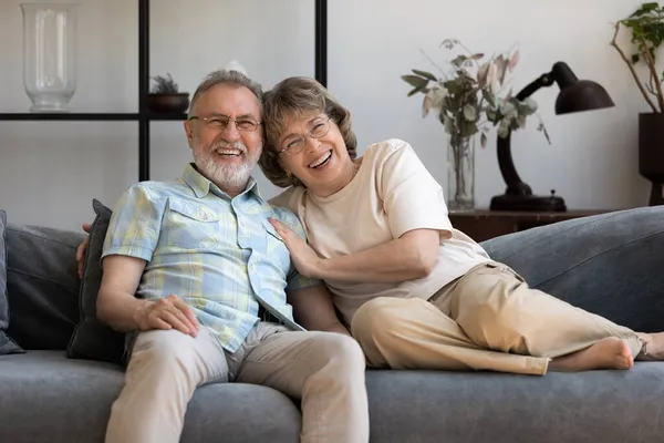 Boldog idősebb 60-as évekbeli pár pihentető nappali otthoni portré — Stock Fotó