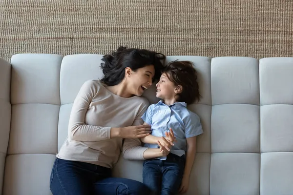 Sopra la vista ridendo mamma e figlio sdraiati sul divano — Foto Stock