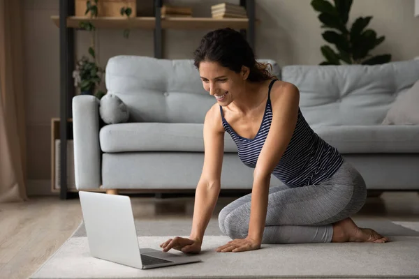Millennial dáma se připojit k virtuální jóga třídy pomocí notebooku — Stock fotografie