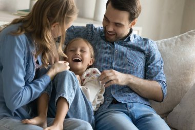 Samimi ebeveynler, evde küçük kızlarını gıdıklıyor..