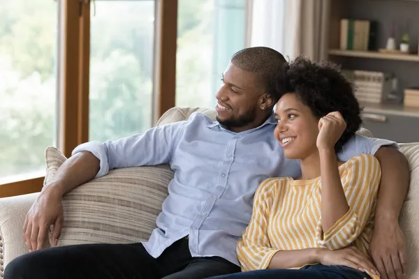 快乐的年轻黑人夫妇在家里的沙发上休息 — 图库照片