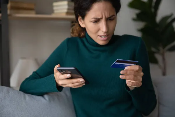 Sorprendido joven latina usando teléfono ver tarjeta bancaria declinó —  Fotos de Stock