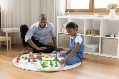 Mutlu Afrikalı Amerikalı baba ve kızı oyuncak kasaba inşa ediyor.