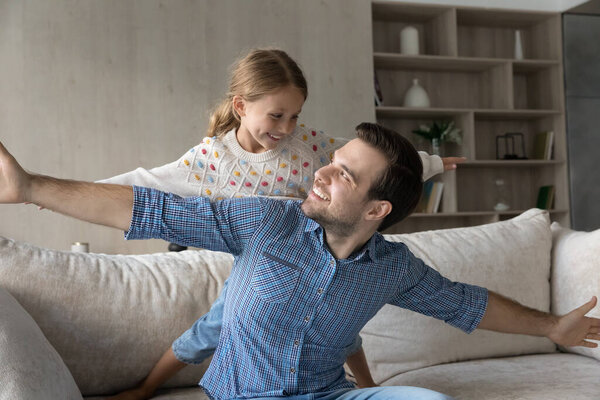 Счастливая маленькая девочка играет с отцом дома.