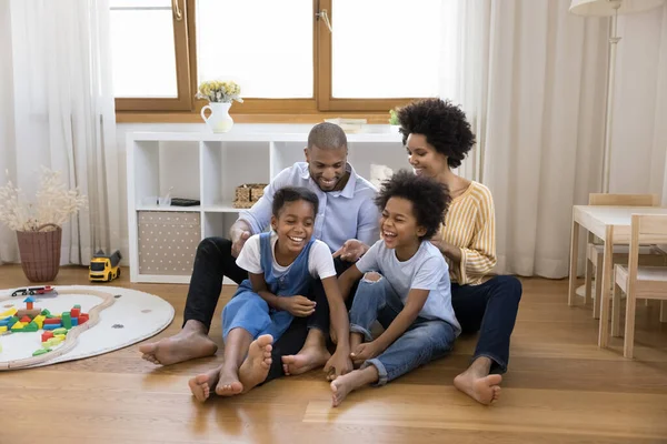 Joyful Black hermanos niños y padres se divierten en el suelo —  Fotos de Stock
