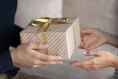 Yakından bir erkek eli sevgili karısına uzun zamandır beklenen hediyeyi veriyor.