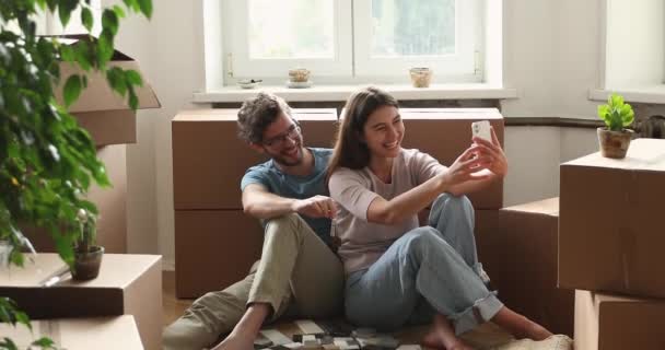 Overjoyed młoda rodzina para mieszkanie kupujący co selfie z kluczami — Wideo stockowe