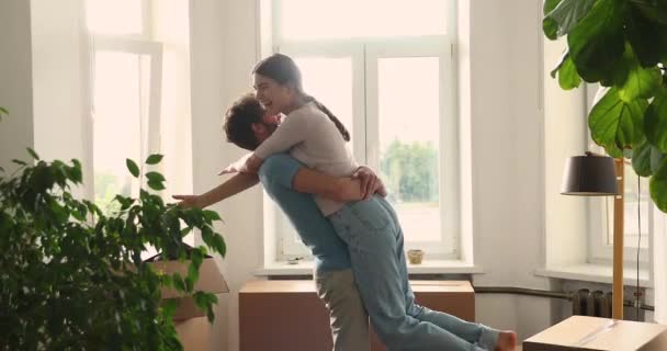 Laughing husband cuddle wife dangling feet in air celebrate mortgage — Stock Video