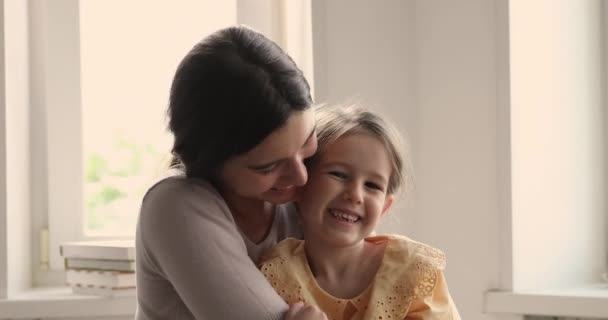 Kopfschuss-Porträt erregt lachende junge Mutter kuschelt kleine Tochter im Vorschulalter — Stockvideo