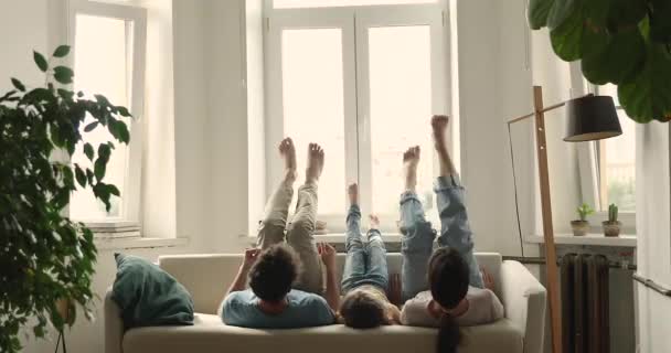 Orangtua dengan anak prasekolah terbaring di sofa bergerak naik kaki — Stok Video