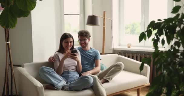 興奮した若いカップルは、携帯電話の画面上の良いニュースメッセージを読む — ストック動画