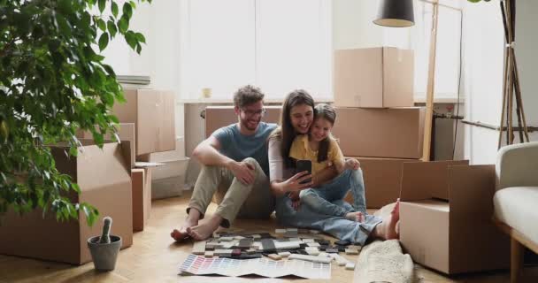 Esposa sosteniendo el teléfono mostrando muestra de la decoración de la hija del marido para la renovación — Vídeos de Stock