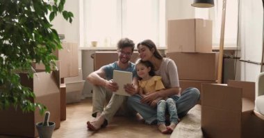 Taşınma gününde çocuklu bir çift tablette selfie çekiyor.