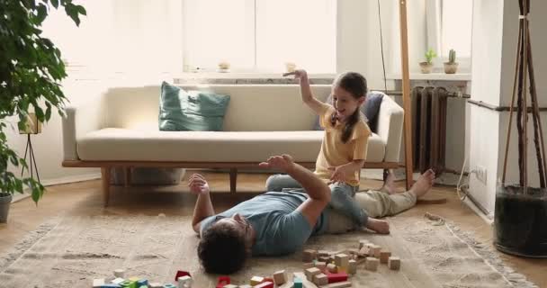 Dziewczyna przedszkolak grać Patty Tort z tatą leżącym na podłodze — Wideo stockowe