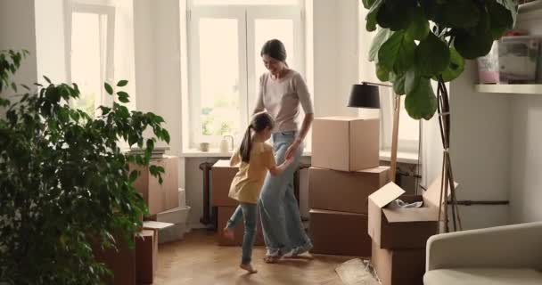 Smějící se mladá maminka tanec s školkou dcera v novém domově — Stock video