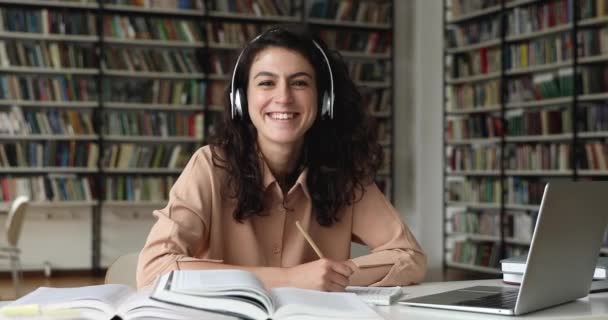 Портрет відмінного студента готується до іспитів у бібліотеці — стокове відео