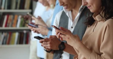 Gençler ellerinde akıllı telefonlar, kapalı kapılar ardında dikiliyorlar.