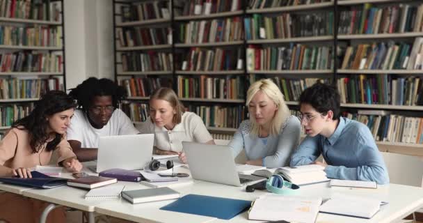 Estudantes multiétnicos usando laptops se preparam para exames na biblioteca — Vídeo de Stock