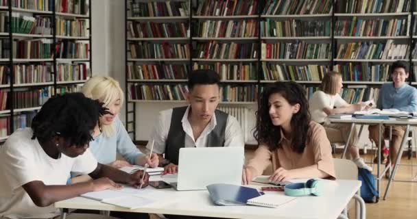 Groupe d'étudiants assis dans la bibliothèque avec un essai d'écriture d'ordinateur portable — Video