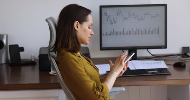 Zaměstnankyně používající buňku rozptýlenou z obrazovky počítače s grafy — Stock video