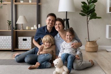 Mutlu ebeveynler ve iki küçük kardeş ev portresi