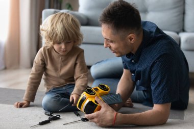 Millennial baba ve tatlı anaokulu çocuğu mekanik oyunlarla meşgul.