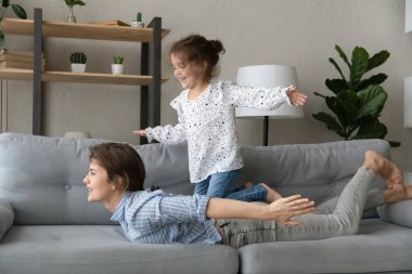 Heyecanlı kız çocuğu denizciyi oynuyor, yelkenli sürüyor.