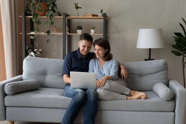 Feliz pareja de citas relajarse en el cómodo sofá en el ordenador — Foto de Stock