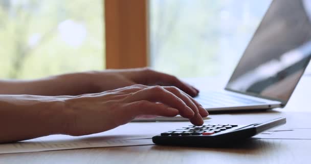Gros plan jeunes mains féminines appuyant sur les touches calculatrice au bureau à la maison — Video