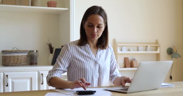 Mujer millennial uso de la calculadora y PC para pagar los servicios públicos en línea — Vídeo de stock