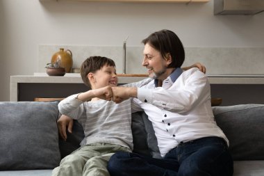 Mutlu genç baba ve genç çocuk yumruk tokuşturuyor..