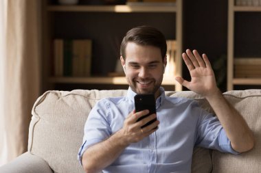 Kablosuz kulaklıklı mutlu milenyum adamı görüntülü konuşma yapıyor.