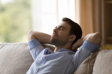 Mutlu rüya gören genç adam evde dinleniyor.