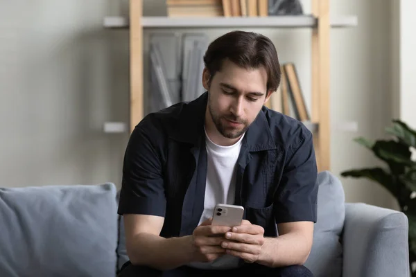 Utente di celle focalizzate che legge messaggi di testo sullo schermo del telefono cellulare — Foto Stock