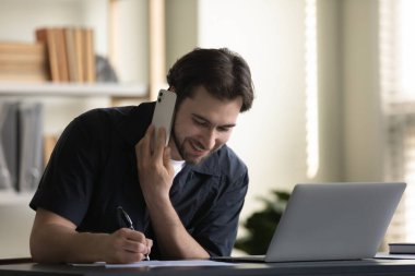 Mutlu bir erkek ofis çalışanı, ofiste telefonla çalışan bir çalışan.