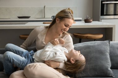 Mutlu genç anne küçük kızıyla oynuyor..