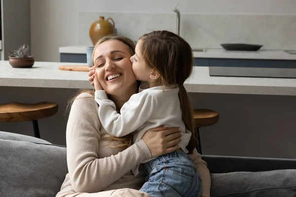 Schattig klein kind meisje zoenen jonge moeder. — Stockfoto