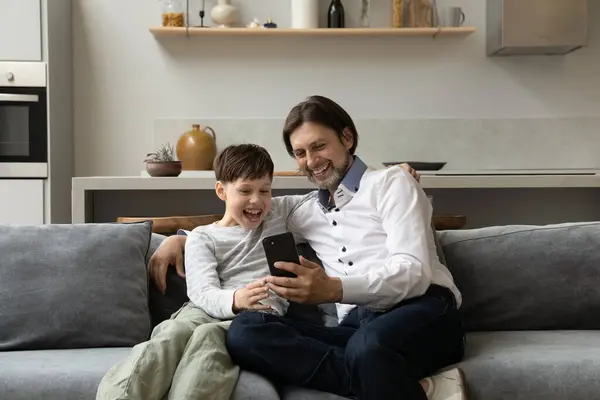 Happy 40 ojciec i nastoletni syn za pomocą telefonu komórkowego. — Zdjęcie stockowe