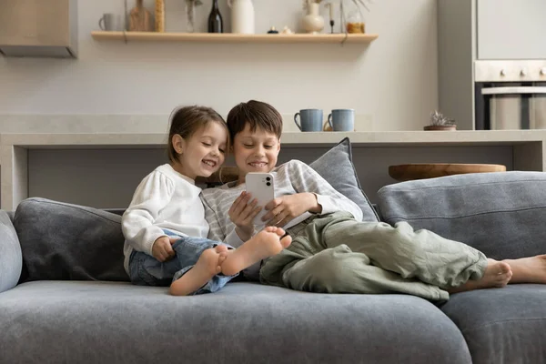 Radosne małe słodkie dzieci za pomocą aplikacji na smartfony. — Zdjęcie stockowe