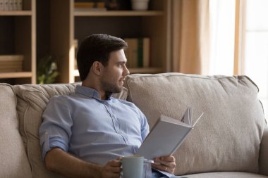 Düşünceli, gevşemiş, keyfine bakan, evde tembellik eden bir adam.