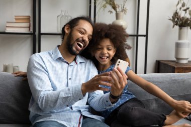 Mutlu Afro-Amerikan ailesi evde cep telefonu kullanıyor..