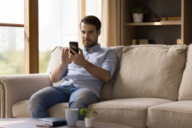 Milenyum adamı kulaklıklı cep telefonunda medya uygulaması kullanıyor.