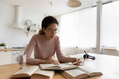 Gözlüklü kadın sınava hazırlanıyor, evde çalışıyor.